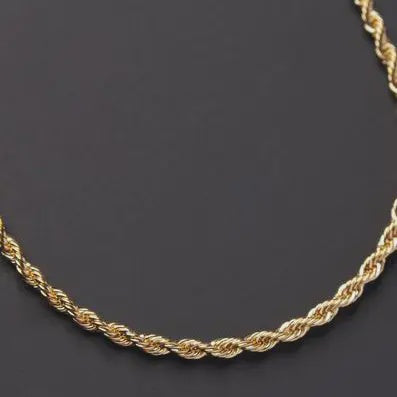 a gold rope necklace on a black background