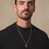 a man with a cross necklace on his neck