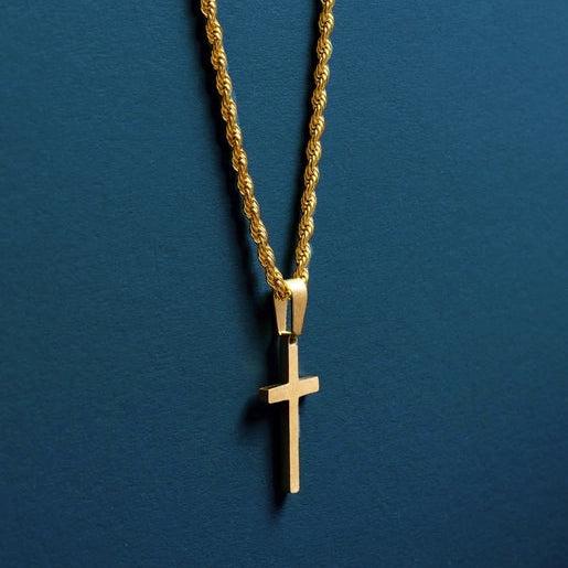 a gold cross necklace on a blue background