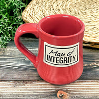 a red coffee mug sitting on top of a wooden table