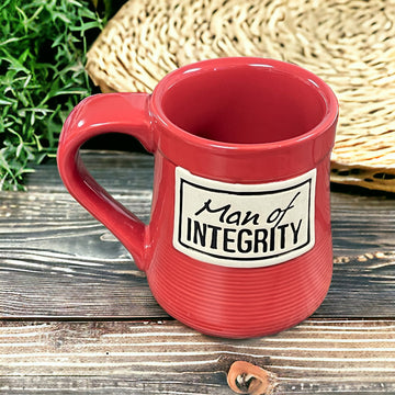 a red coffee mug sitting on top of a wooden table