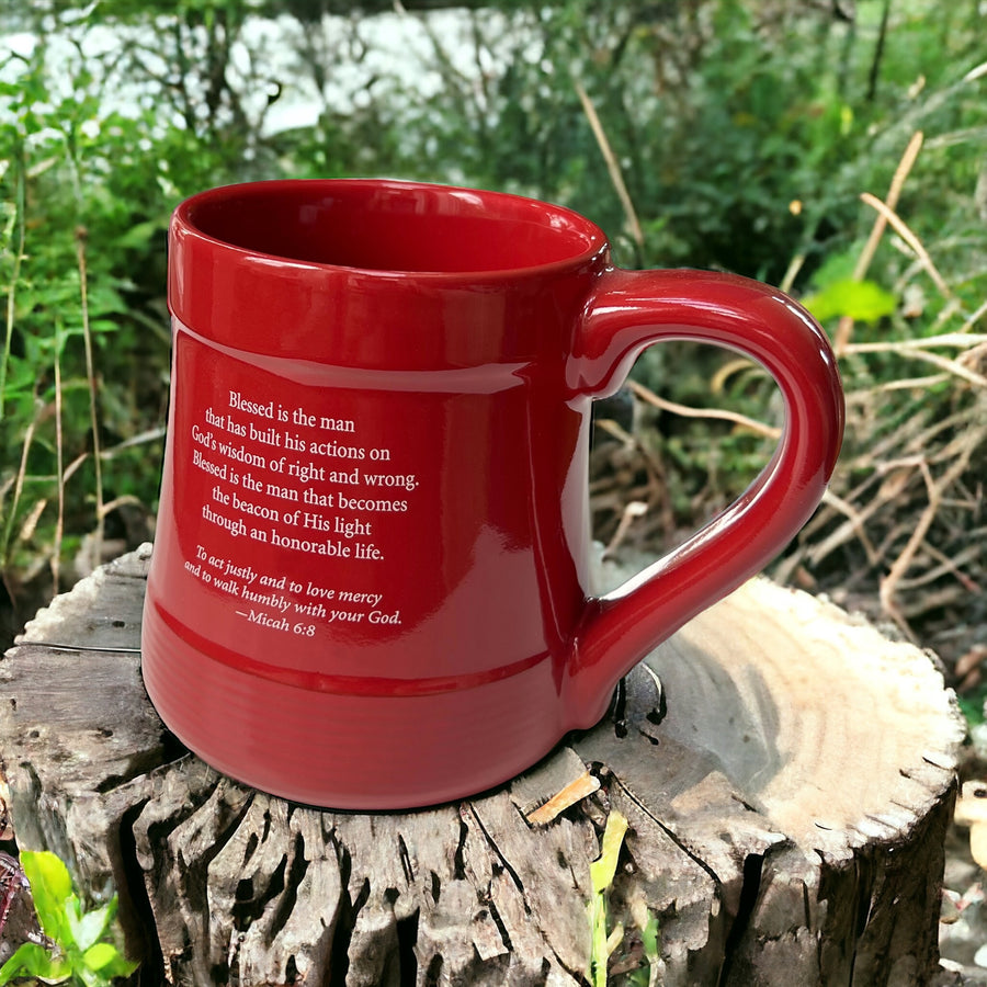 a red mug sitting on top of a tree stump